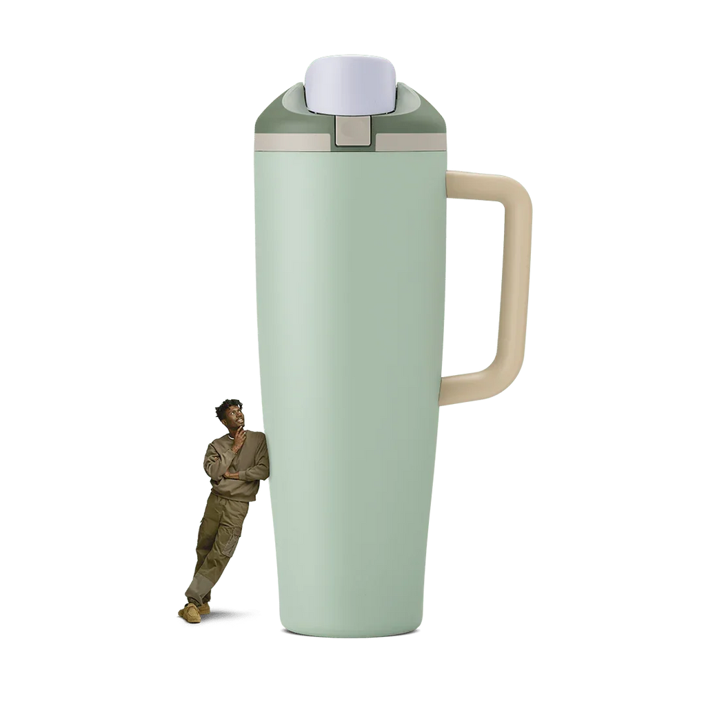40oz eucalyptus green travel tumbler with beige handle and lid, person leaning on it for scale