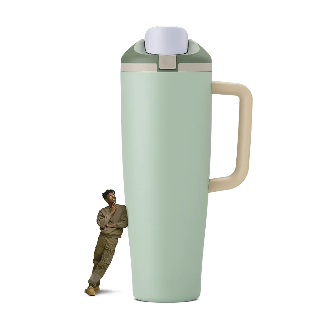 40oz eucalyptus green travel tumbler with beige handle and lid, person leaning on it for scale