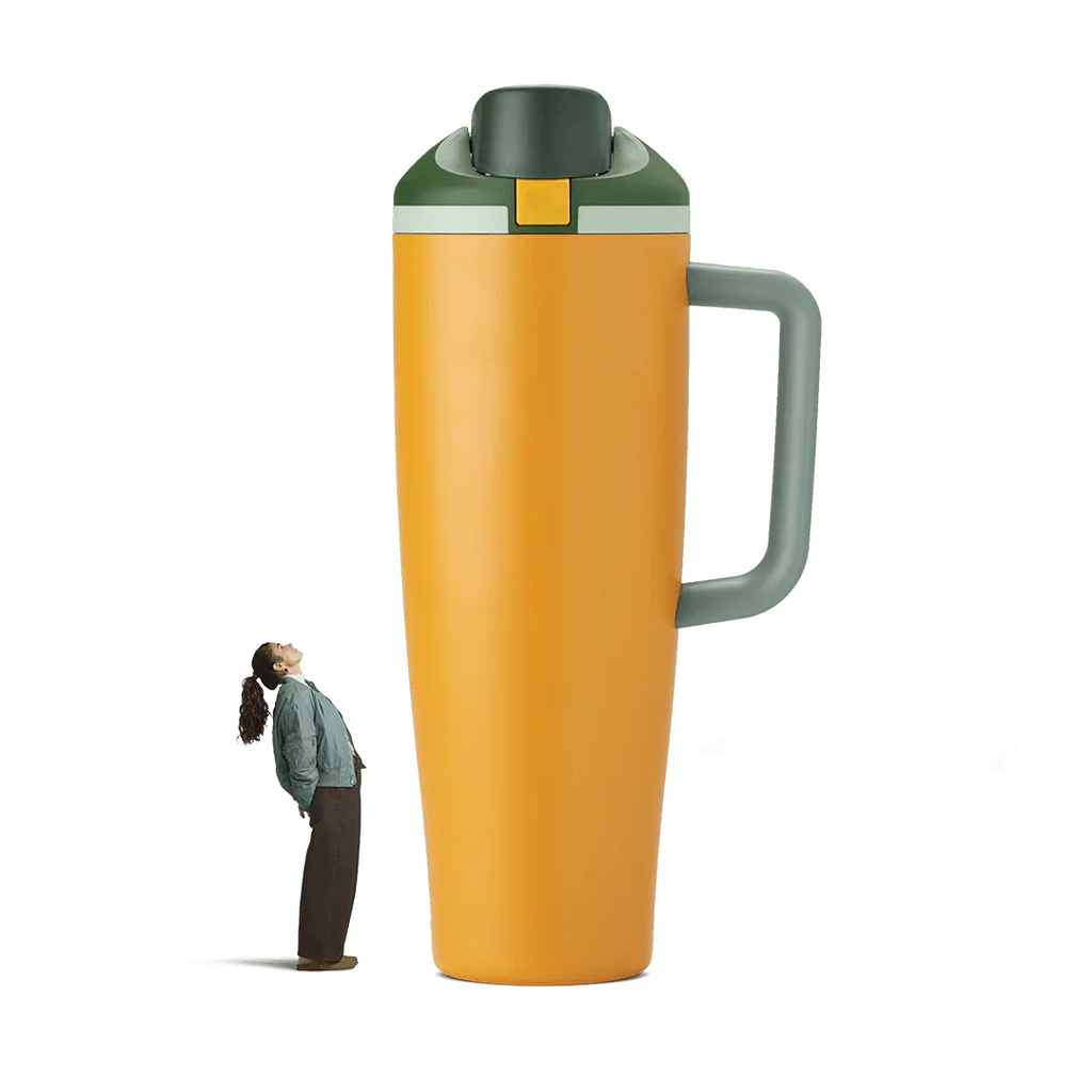 Tall orange and green insulated tumbler with gray handle, standing next to person for size comparison