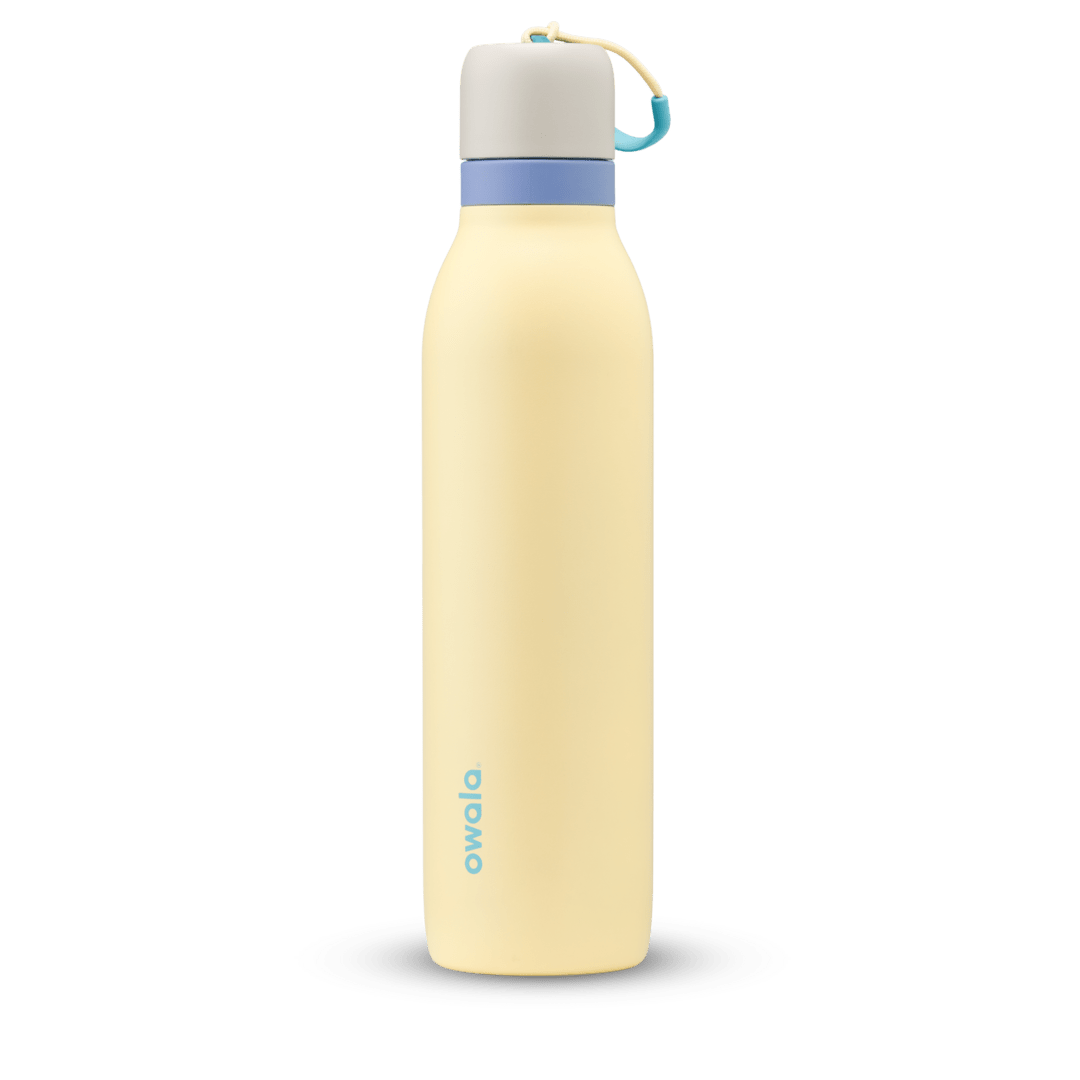 Owala 24oz insulated water bottle in pastel yellow with blue cap and carrying loop